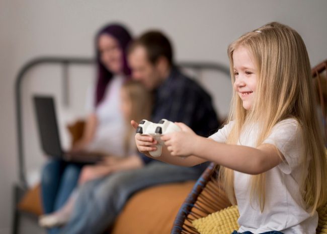 Jeux vidéo en famille : petite fille jouant à la console avec un joystick