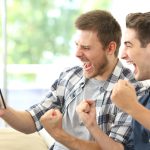 Deux amis regardant du sport sur une tablette