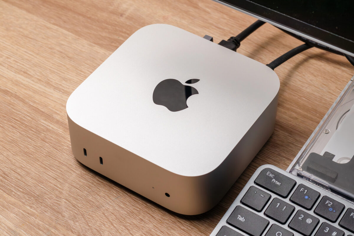 Mac mini d'Apple posé sur un bureau en bois à côté d'un clavier, l'ordinateur compact prisé pour l'IA locale